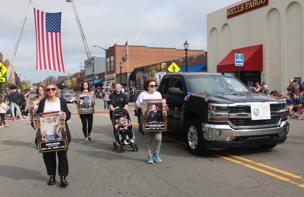 Marchers following a vehicle carrying photos of the fallen