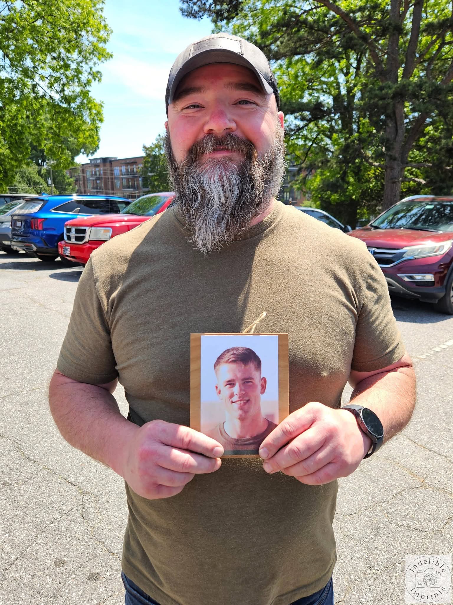 A supporter holding a memorial photo of a fallen service member