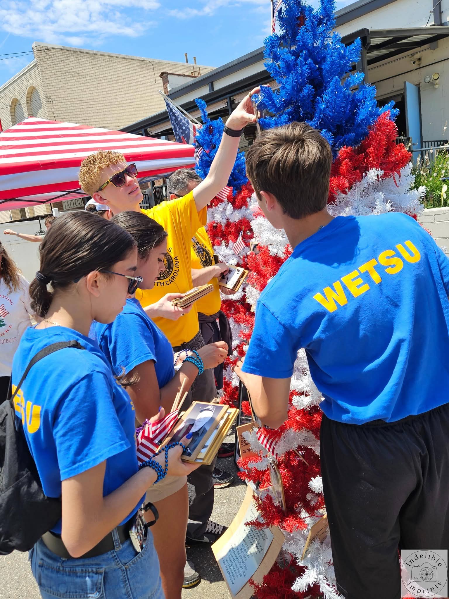 Students placing memorial photos on a tribute tree at a Let's Talk Strength event