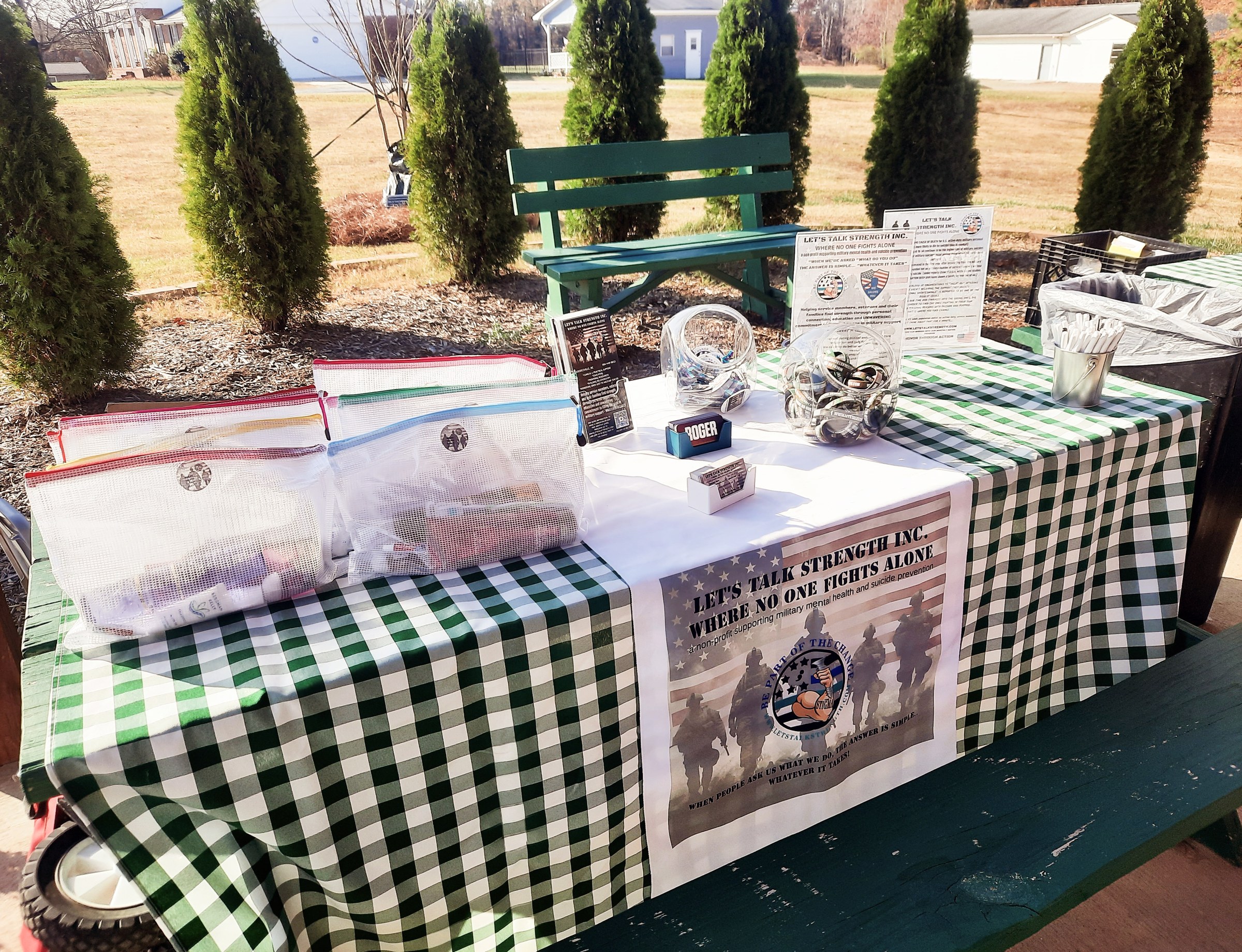 A Let's Talk Strength volunteer outreach table set up with care package bags